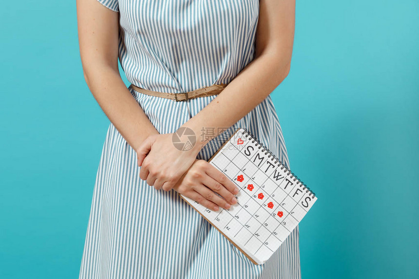 穿着蓝色连衣裙的裁剪拍摄病妇女拿着周期日历检查月经天数图片