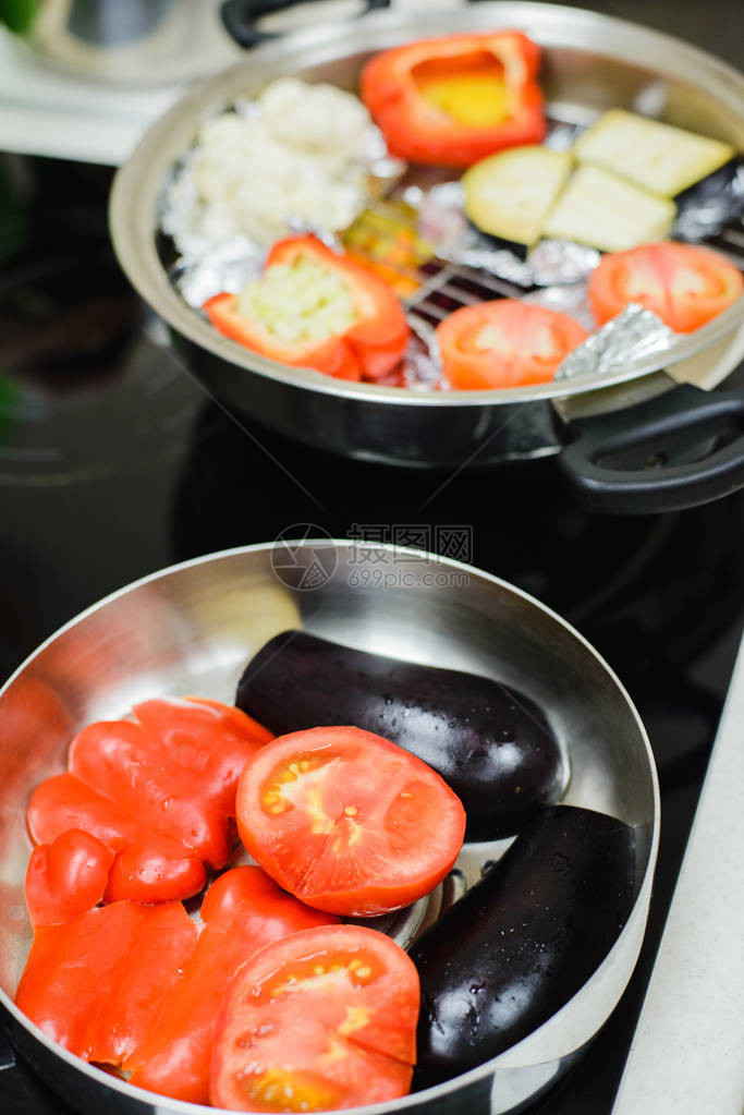 切片西红茄黄番茄烤锅中的辣椒和电炉灶中炖菜的泡粉图片