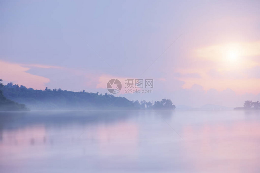 随着日出湖面上的薄雾正在蔓延到地平线图片