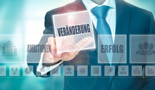 一个商人在未来的计算机显示上按着德语的更改Verander图片