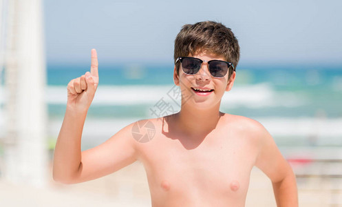 在海滩边度假的幼童惊讶于一个想法或问题与快乐的面孔对图片