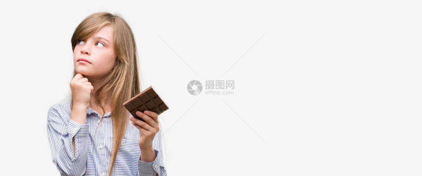 年轻金发女孩拿着巧克力棒面对着严肃的表情思考问题非图片