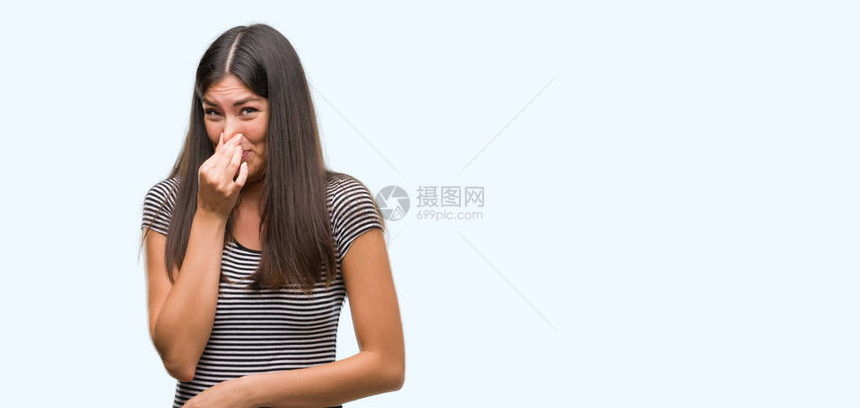 年轻美丽的弥漫女闻到一些臭味恶心难以忍受的气味图片