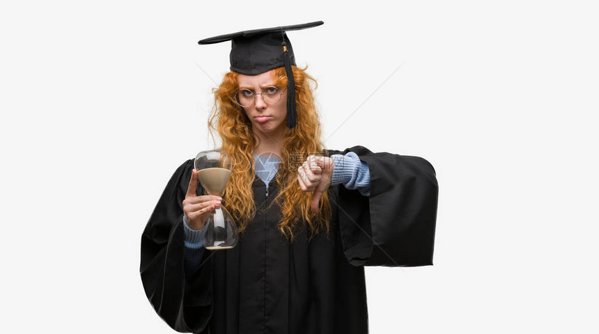 穿着毕业制服的年轻红发女学生拿着沙漏图片