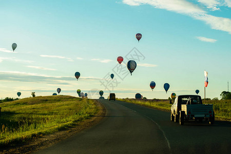 色彩鲜艳的热气球飞过田野图片