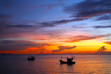 海上剪影小船和五颜六色的日落背景图片