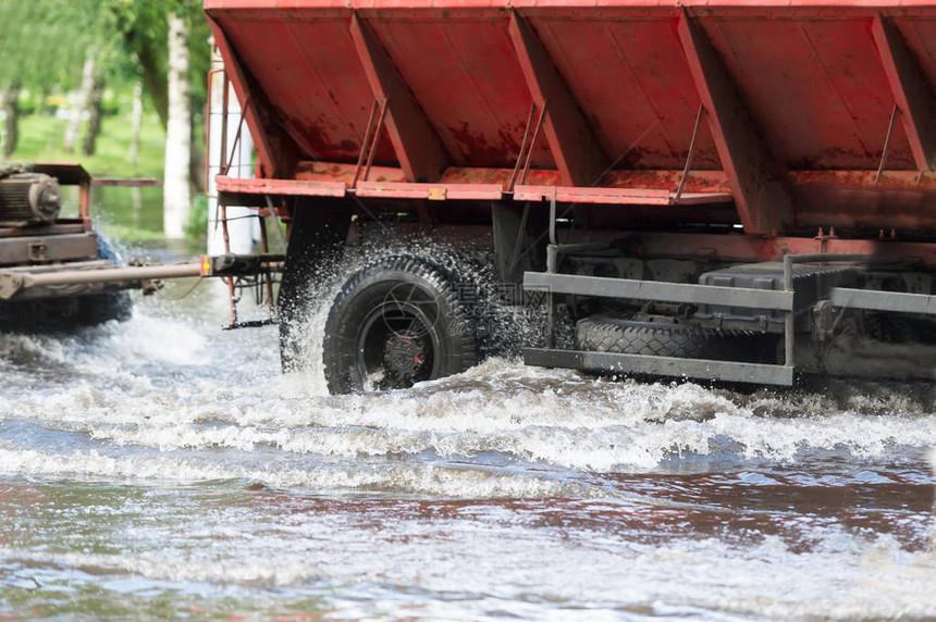 由一辆卡车和拖车在经过洪水时喷图片