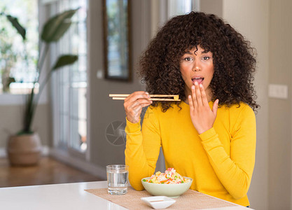 非裔美国妇女在家中吃亚洲大米时用手顶嘴图片