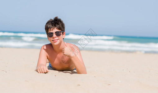 小孩子在海滩度假时开心地笑着做好手势图片