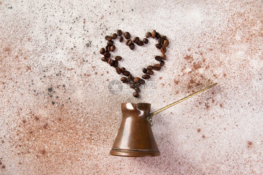 古铜咖啡壶和咖啡豆的心脏形状图片