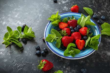 蓝莓和草莓沙拉在碗里用新鲜的野生薄荷图片