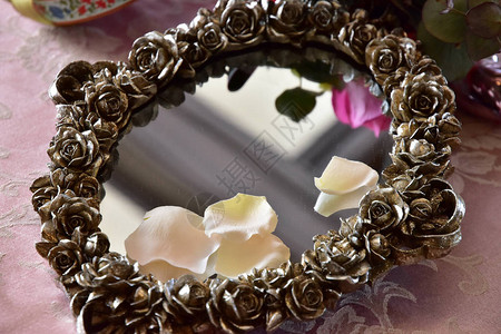 房间桌子上装饰着花的镜子背景图片