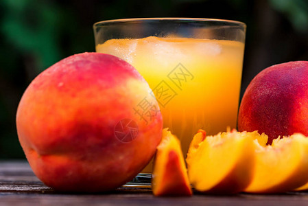 用桃子冰沙和新鲜桃子在木质表面关闭玻璃选择焦点健康图片