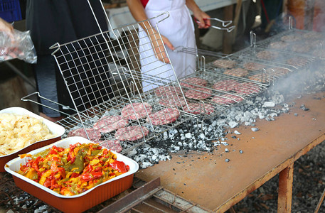 在乡村节的烤架上做牛肉汉堡以及胡椒背景图片