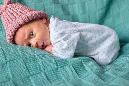 新生儿在床上的婴儿女孩吓了一跳的冬衣图片