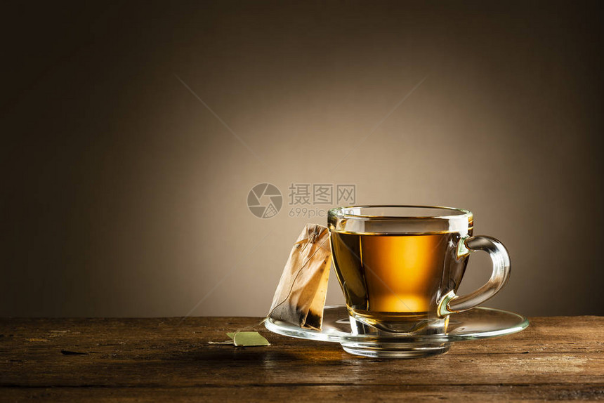 玻璃杯茶和木桌上的茶包图片