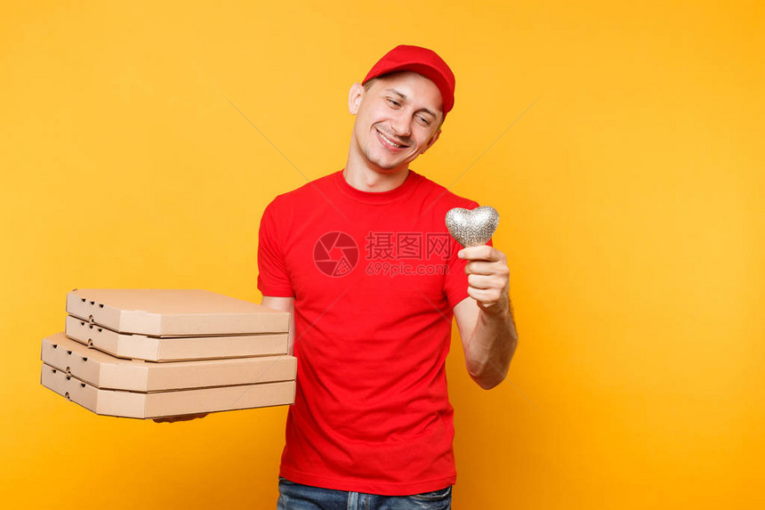 送货员在帽t恤给食品订单披萨盒隔离在黄色背景身着制服的男员工比萨饼快递员在纸板箱里拿着心形意大利比萨图片
