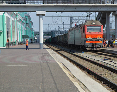 现代机车运载货运列车经过火车站这图片