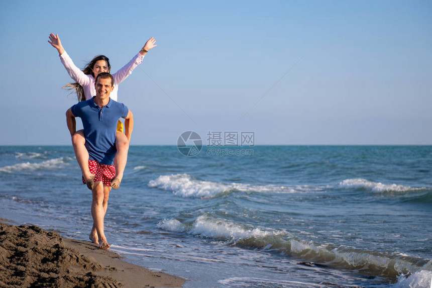 在沙滩上背着女人的男人图片