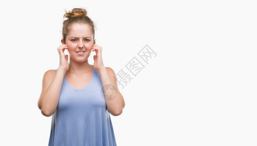 年轻金发女子用手指遮住耳朵图片