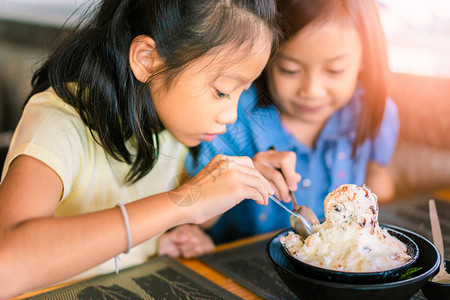 亚洲小女孩喜欢在餐厅吃冰淇淋或冰糖图片