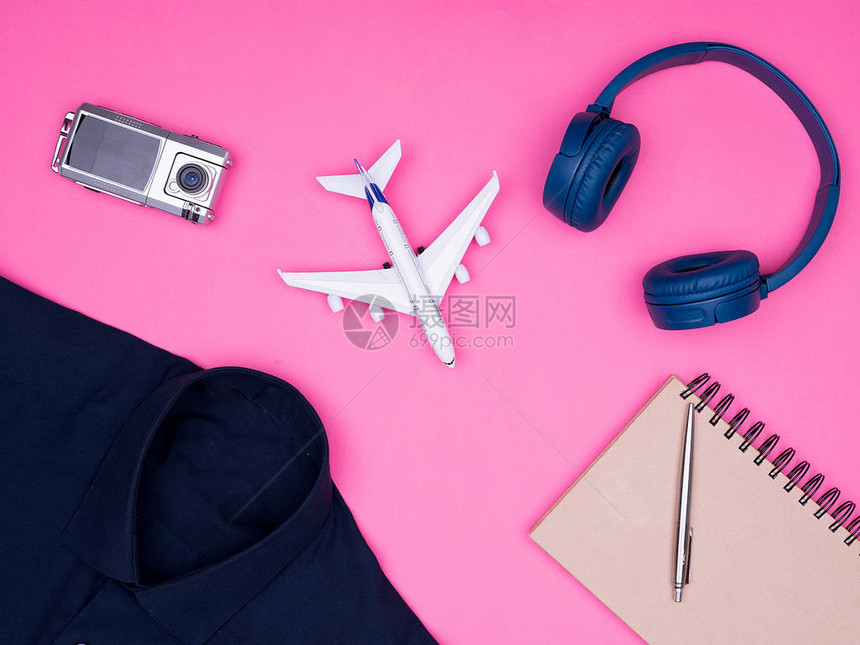 在粉红色背景耳机照相机笔记本上贴有旅行者摄影师配图片