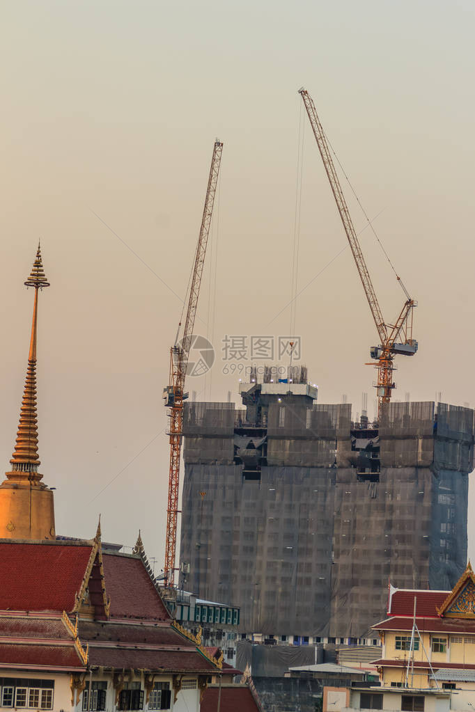 高层建筑中钢框架上公寓施工现场的动臂塔式起重机摩天大楼建筑施工与塔式起重机在戏剧天空图片