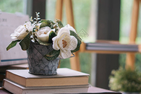 背景模糊的花盆中的人造植物和玫瑰图片