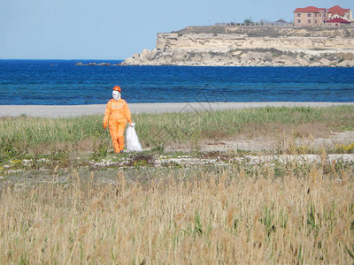 橙色内衣的工人正在清理海滩哈萨克图片