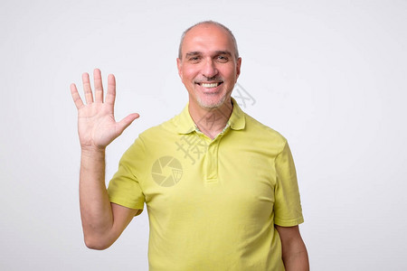 看起来友善有魅力的欧洲男人一边挥手打招呼图片