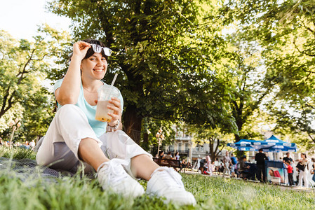 在市公园喝酷饮的女人背景模图片
