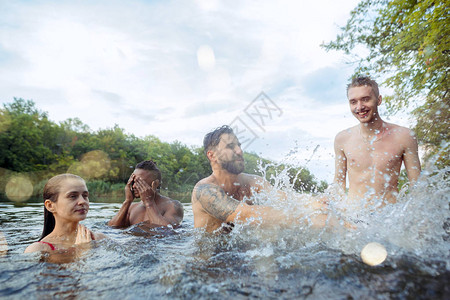 与朋友一起享受森林派对一群美丽快乐的年轻男女一起在河里游泳夏天图片