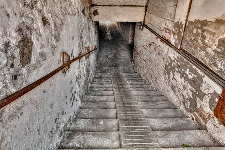 下到地下通道下降与楼梯到一个狭窄的黑暗画廊在图片