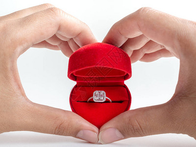 红色心形盒中的钻石戒指白色背景中孤立的图片