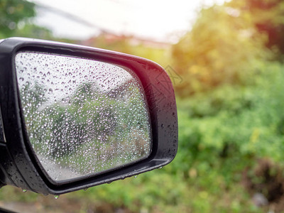 水滴雨滴在有树背景的汽车后视镜上图片