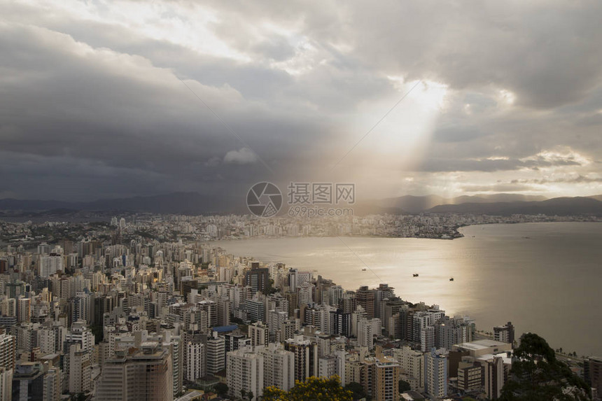 城市区的全景建筑物和海湾上闪耀着光线远处雨云多彩云弗洛里亚诺波利斯圣卡图片