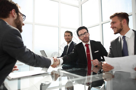 在谈判桌上握手商界人士理念图片