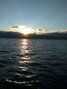 日落后海平面上的发光云层海上日落海景背景图片