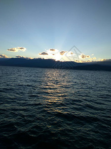 日落后海平面上的发光云层海上日落海景背景图片