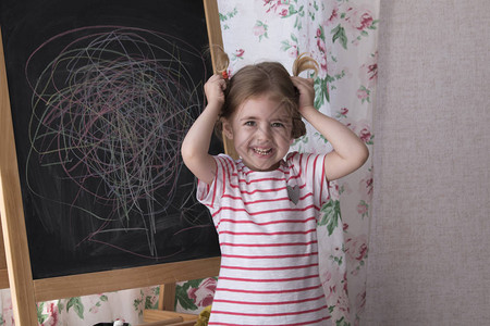 孩子在黑板上用彩色粉笔作画图片