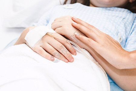 医院中母亲手持小女孩的手静脉注射四图片
