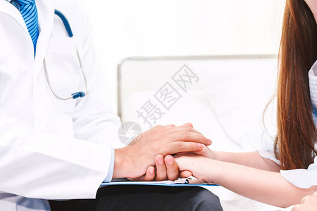 医生在医院的医生桌子上照料顾着手持小女儿图片