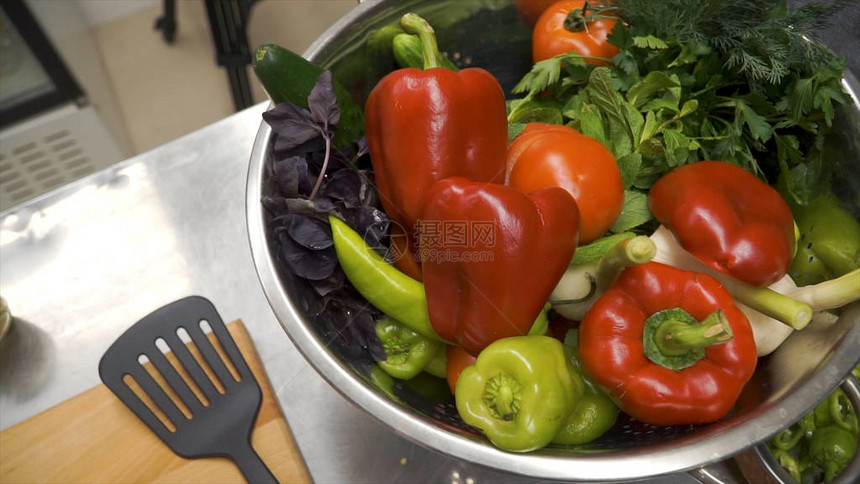刀在木菜板上切红甜椒夹子在木菜板上用甜椒切芯用刀从红甜椒中取出种子蔬菜的制备图片