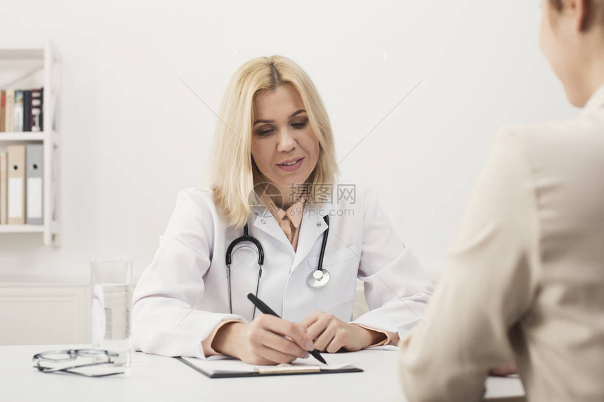 快乐的女医生咨询坐在医院里的女图片