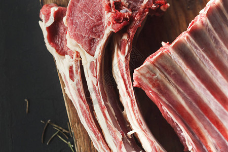 生切羊排在黑色背景的木板上的新鲜肉餐厅用餐的有机食材顶视图片
