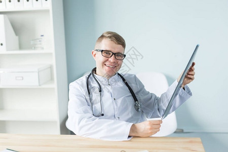 医疗保健医疗和人的概念微笑的在线医生坐在手里图片