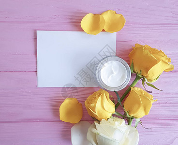 化妆品奶油粉红色木质背景上的黄玫瑰图片