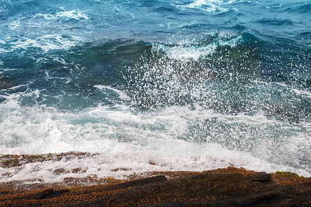 从大海坠毁到布拉瓦海滩岸岩石的波浪图片