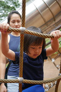 成人观看的亚裔儿童攀爬图片