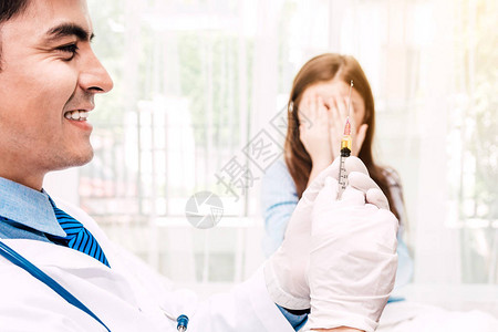 戴着防护手套的医生在医院的医生桌上给小女孩注射医图片